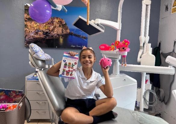 Girl showing off prizes and stickers after dental visit